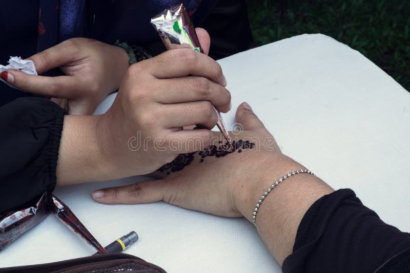 Καλλιτέχνης που εφαρμόζει henna τη δερματοστιξία σε ετοιμότητα γυναικών στοκ φωτογραφία Καλλιτέχνης που εφαρμόζει henna τη δερματοστιξία σε ετοιμότητα γυναικών στοκ φωτογραφία