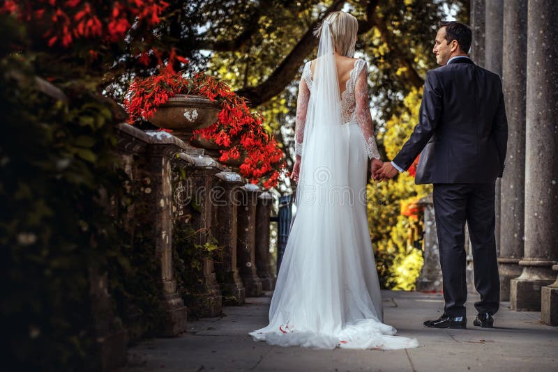 Καλό ζεύγος των newlyweds - νύφη και νεόνυμφος που περπατούν γύρω από ένα παλαιό όμορφο παλάτι πετρών υπαίθρια στοκ εικόνες με δικαίωμα ελεύθερης χρήσης
