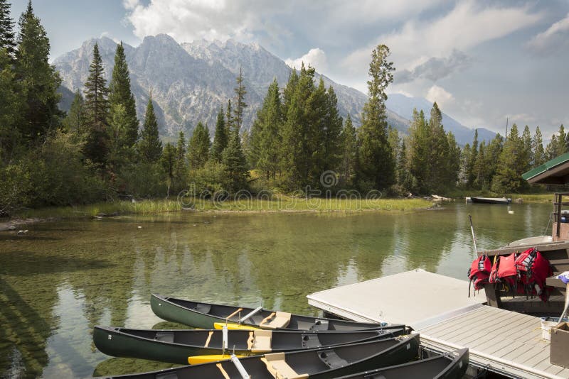 Κανό, αποβάθρα και βουνά στη λίμνη της Jenny, Jackson Hole, Ουαϊόμινγκ στοκ εικόνες