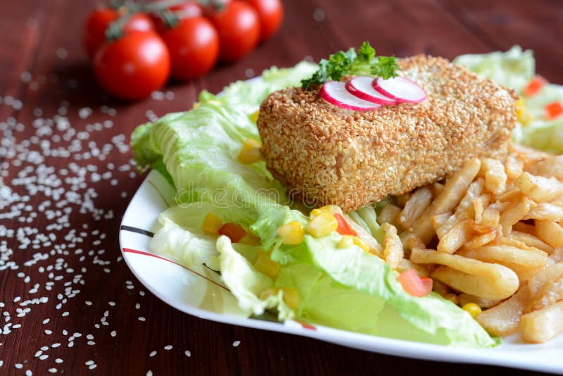 Καπνισμένο tofu που καλύπτεται στους σπόρους σουσαμιού με τα τηγανητά ρίζας σέλινου στοκ φωτογραφία
