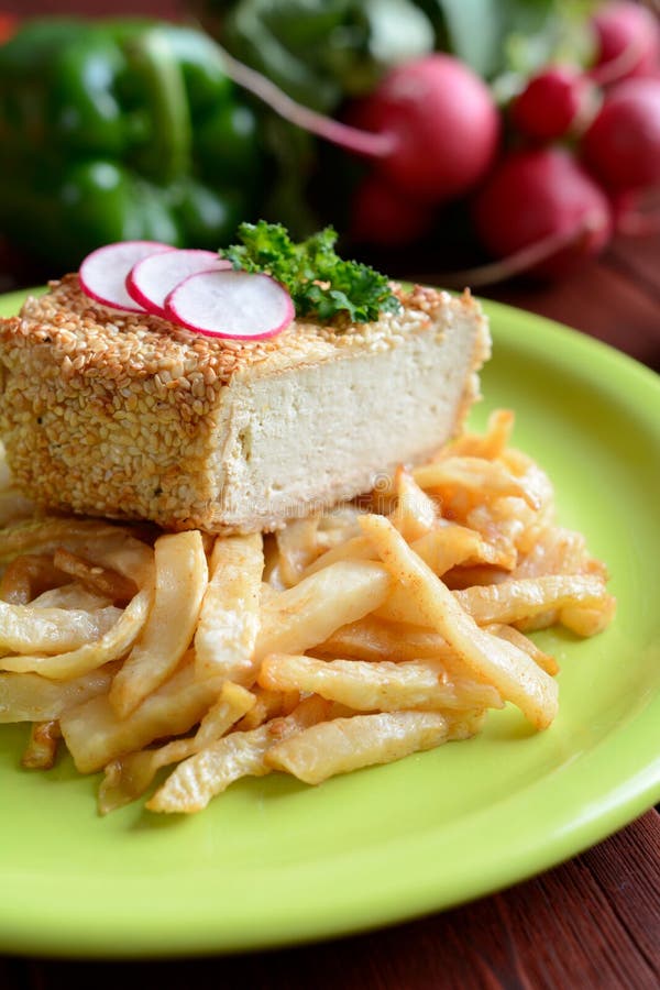 Καπνισμένο tofu που καλύπτεται στους σπόρους σουσαμιού με τα τηγανητά ρίζας σέλινου στοκ εικόνες