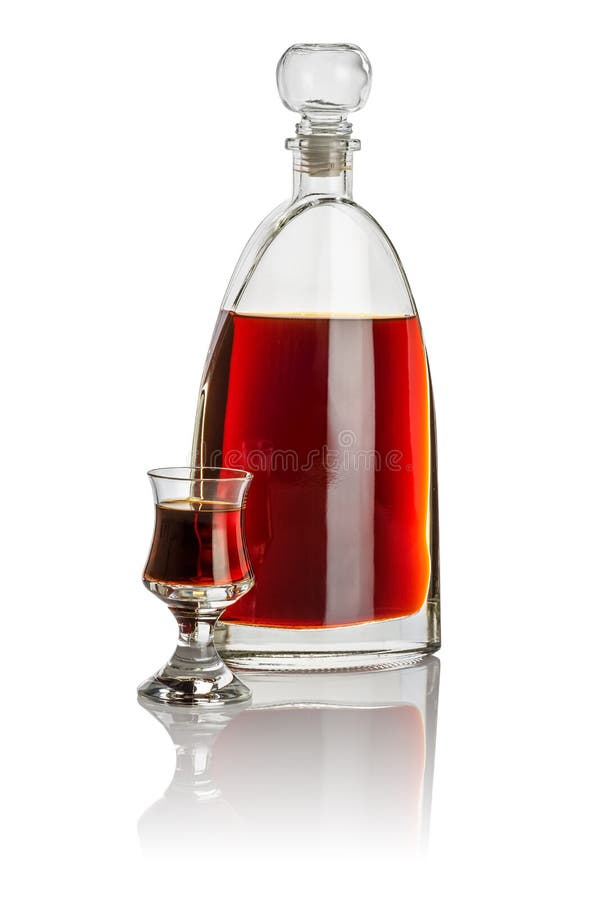 Καράφα και schnapps γυαλί που γεμίζουν με το καφετί υγρό στοκ φωτογραφία με δικαίωμα ελεύθερης χρήσης