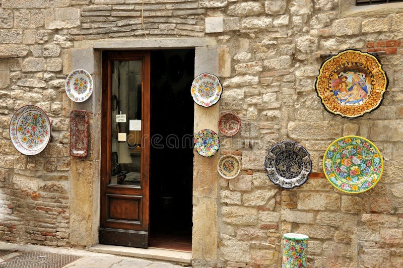 Gubbio, typical majolica artifact shop. The historical centre of Gubbio has a medieval aspect: the town is austere in appearance because of the dark grey stone, narrow streets, and Gothic architecture. Many houses in central Gubbio date to the 14th and 15th centuries, and were originally the dwellings of wealthy merchants. Gubbio, typical majolica artifact shop. The historical centre of Gubbio has a medieval aspect: the town is austere in appearance because of the dark grey stone, narrow streets, and Gothic architecture. Many houses in central Gubbio date to the 14th and 15th centuries, and were originally the dwellings of wealthy merchants.