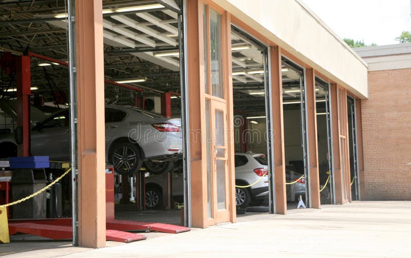 Cars in an engine bay at a repair shop where cars can have a tune-ups, brake job, oil change, transmission service, check engine lights and air conditioning repaired. Cars in an engine bay at a repair shop where cars can have a tune-ups, brake job, oil change, transmission service, check engine lights and air conditioning repaired.