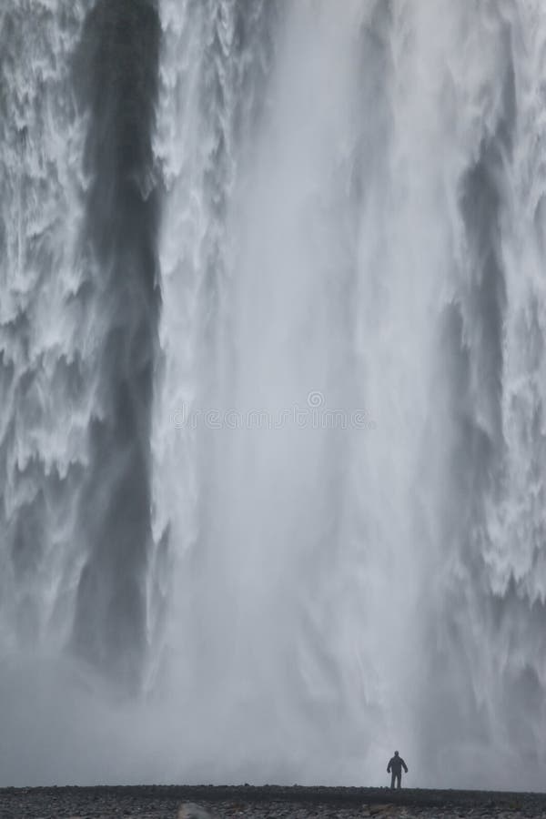 Skogafoss waterfall in Iceland, so huge it makes us humans look insignificant and powerless. Skogafoss waterfall in Iceland, so huge it makes us humans look insignificant and powerless