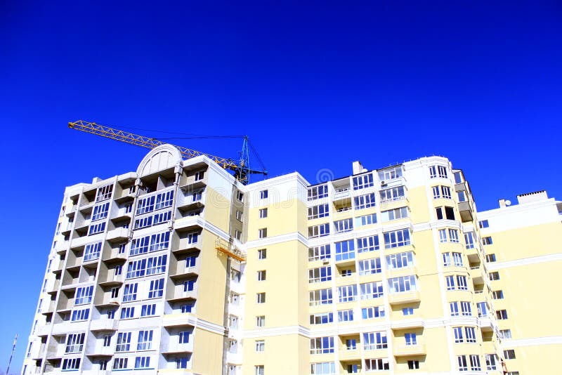 Κατασκευή του multistorey σύγχρονου σπιτιού με την ανύψωση του γερανού στοκ φωτογραφία