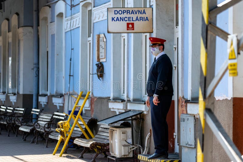 RUZOMBEROK, SLOVAKIA - APRIL 1, 2020: Steward with face mask and empty train station. RUZOMBEROK, SLOVAKIA - APRIL 1, 2020: Steward with face mask and empty train station