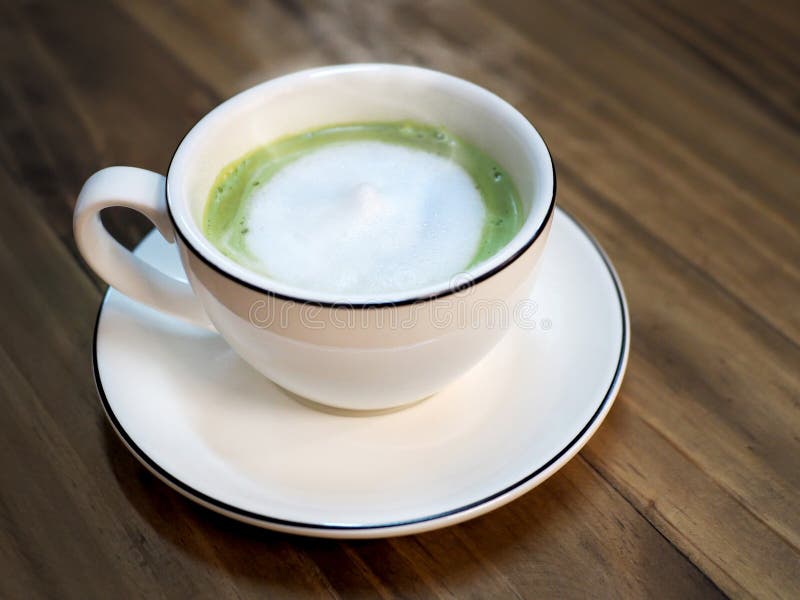 Καυτό πράσινο τσάι matcha latte με το φλυτζάνι αφρού γάλακτος στον ξύλινο πίνακα στον καφέ Καθιερώνουσα τη μόδα τροφοδοτημένη τάσ στοκ φωτογραφίες με δικαίωμα ελεύθερης χρήσης Καυτό πράσινο τσάι matcha latte με το φλυτζάνι αφρού γάλακτος στον ξύλινο πίνακα στον καφέ Καθιερώνουσα τη μόδα τροφοδοτημένη τάσ στοκ φωτογραφίες με δικαίωμα ελεύθερης χρήσης
