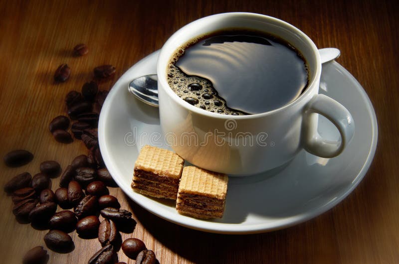 A cup of coffee with coffee beans in background. A cup of coffee with coffee beans in background