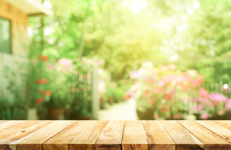 Κενή ξύλινη επιτραπέζια κορυφή στην περίληψη θαμπάδων πράσινη από τον κήπο