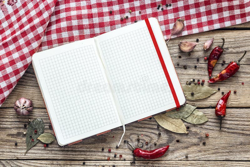 Κενό ανοικτό cookbook με τα καρυκεύματα και μια ελεγμένη πετσέτα στοκ εικόνα με δικαίωμα ελεύθερης χρήσης Κενό ανοικτό cookbook με τα καρυκεύματα και μια ελεγμένη πετσέτα στοκ εικόνα με δικαίωμα ελεύθερης χρήσης