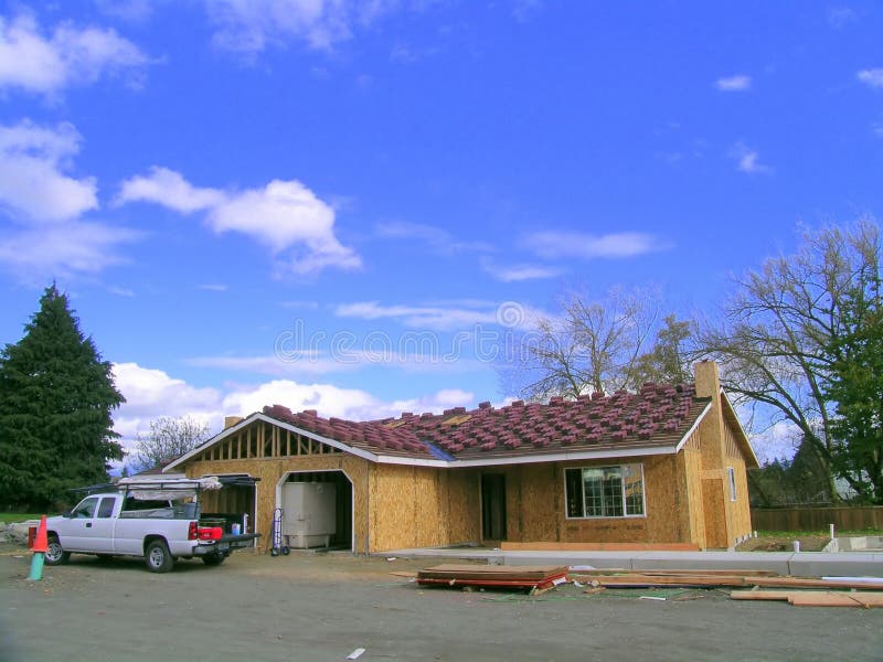 Plumbing contractor truck on a job site, new tile roofing is awaiting installation. Plumbing contractor truck on a job site, new tile roofing is awaiting installation