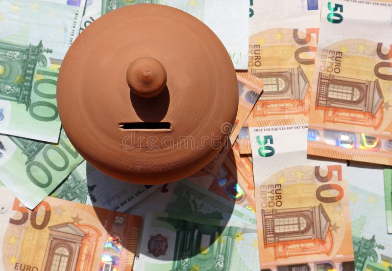 Κιβώτιο αποταμίευσης χρημάτων αργίλου, ή piggy τράπεζα, σε ένα κρεβάτι των ευρο- τραπεζογραμματίων διεσπαρμένων στοκ φωτογραφία Κιβώτιο αποταμίευσης χρημάτων αργίλου, ή piggy τράπεζα, σε ένα κρεβάτι των ευρο- τραπεζογραμματίων διεσπαρμένων στοκ φωτογραφία