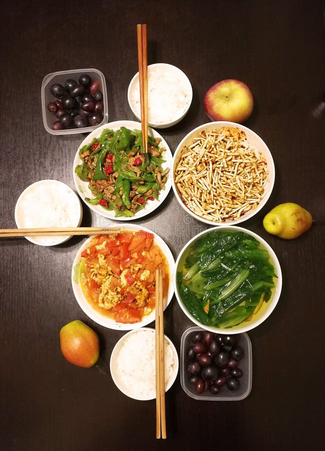 There is a Chinese dinner for 3 people in one typical Chinese modern family, 2 adults and 1 child. Chinese dishes contain eggs, tomatoes,vegetable fruit and rice on a black background. There is a Chinese dinner for 3 people in one typical Chinese modern family, 2 adults and 1 child. Chinese dishes contain eggs, tomatoes,vegetable fruit and rice on a black background.