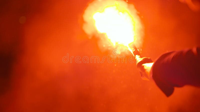 Κινηματογράφηση σε πρώτο πλάνο μιας καίγοντας φλόγας σημάτων που κατέχει ένα άτομο