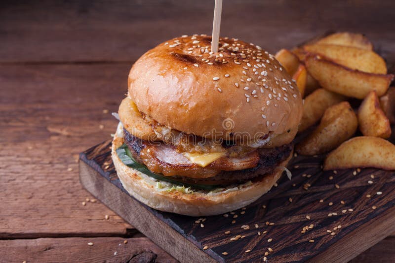 Κινηματογράφηση σε πρώτο πλάνο νόστιμο Burger με τα πρόχειρα φαγητά υπό μορφή πατατών με την άσπρη σάλτσα σκόρδου Juicy Burger με στοκ εικόνες Κινηματογράφηση σε πρώτο πλάνο νόστιμο Burger με τα πρόχειρα φαγητά υπό μορφή πατατών με την άσπρη σάλτσα σκόρδου Juicy Burger με στοκ εικόνες