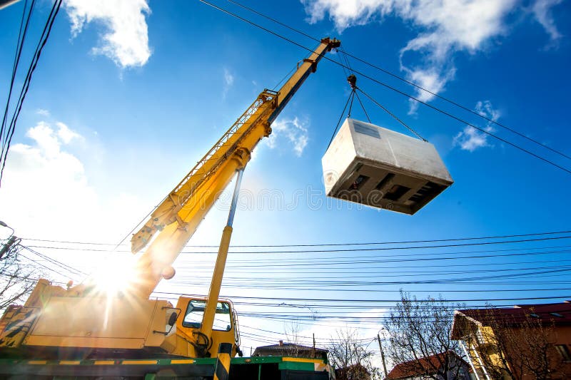 Mobile crane operating by lifting and moving an heavy electric generator. Mobile crane operating by lifting and moving an heavy electric generator