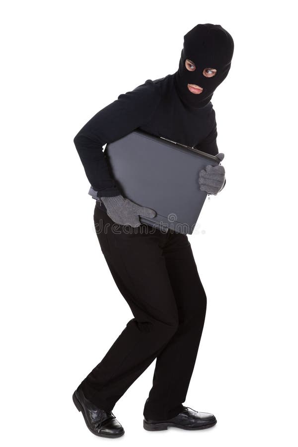 Thief dressed in black and wearing a balaclava stealing a laptop computer and making a furtive escape isolated on white. Thief dressed in black and wearing a balaclava stealing a laptop computer and making a furtive escape isolated on white