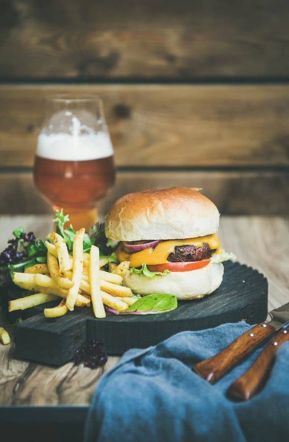 Κλασικό burger γεύμα με τις τηγανιτές πατάτες, σαλάτα, μπύρα στοκ εικόνες