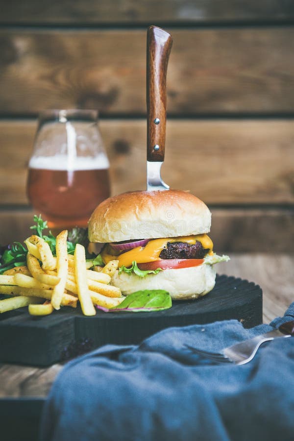 Κλασικό burger γεύμα με το ποτήρι της μπύρας και των τηγανιτών πατατών στοκ εικόνες