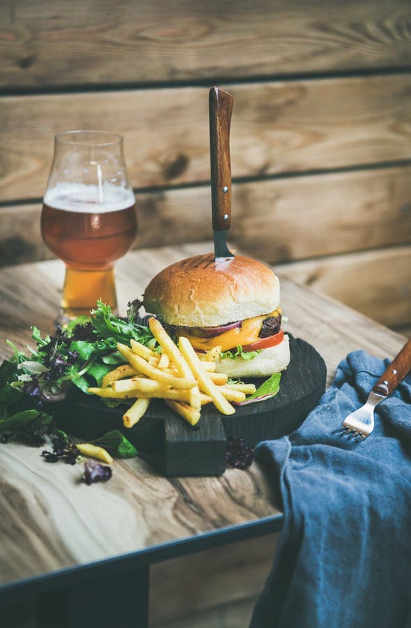 Κλασικό burger γεύμα με το ποτήρι της μπύρας και των τηγανιτών πατατών στοκ φωτογραφίες με δικαίωμα ελεύθερης χρήσης