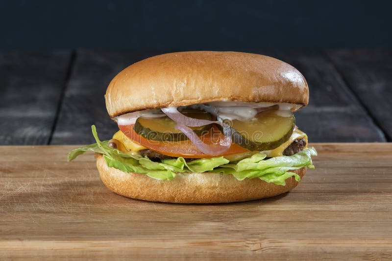 Κλασικό burger στον ξύλινο πίνακα στοκ εικόνες