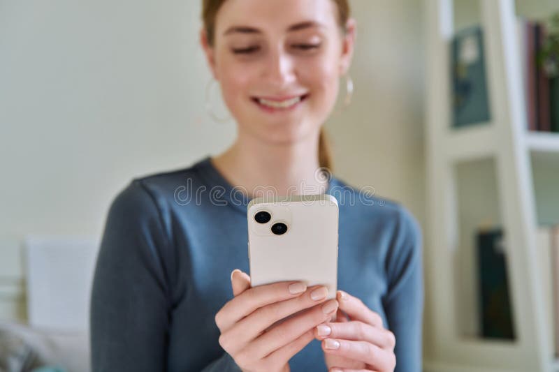 Close-up of smartphone in hands of young smiling woman. Happy teenage female using phone, texting, reading. Modern wireless technologies, Internet, online, mobile apps applications, digital gadgets. Close-up of smartphone in hands of young smiling woman. Happy teenage female using phone, texting, reading. Modern wireless technologies, Internet, online, mobile apps applications, digital gadgets