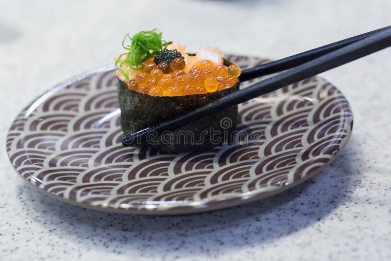 Κλείστε επάνω chopsticks τη λαβή στο φρέσκο σολομό σουσιών Ιαπωνικά τρόφιμα για υγιή στοκ εικόνες Κλείστε επάνω chopsticks τη λαβή στο φρέσκο σολομό σουσιών Ιαπωνικά τρόφιμα για υγιή στοκ εικόνες
