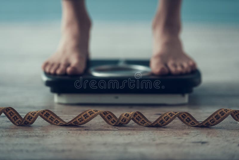 κλείστε επάνω Νέα γυναίκα που στέκεται Weigher στο πάτωμα στοκ εικόνα κλείστε επάνω Νέα γυναίκα που στέκεται Weigher στο πάτωμα στοκ εικόνα