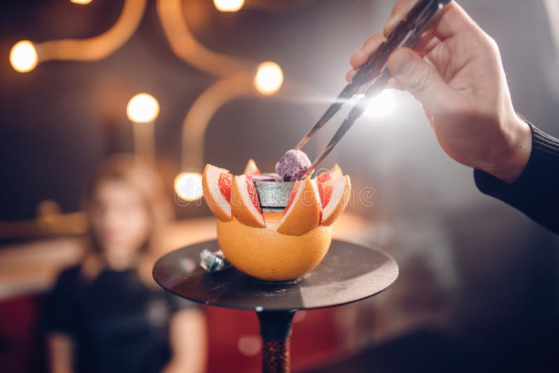 κλείστε επάνω Ο άνθρακας ατόμων Hookah ποικίλλει στο κύπελλο γκρέιπφρουτ Θαμπάδα υποβάθρου, έντονο φως στοκ εικόνα κλείστε επάνω Ο άνθρακας ατόμων Hookah ποικίλλει στο κύπελλο γκρέιπφρουτ Θαμπάδα υποβάθρου, έντονο φως στοκ εικόνα