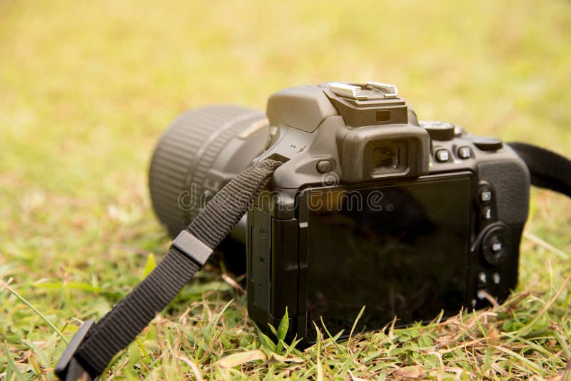 Κλείστε επάνω τη κάμερα DSLR στο πράσινο πάτωμα χλόης