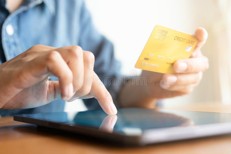Κλείστε επάνω το χέρι των επιχειρηματιών αγοράζει on-line με μια πιστωτική κάρτα Τα άτομα χρησιμοποιούν την ταμπλέτα και κάνουν τ στοκ εικόνες