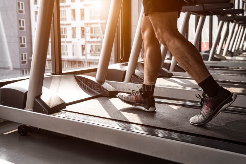 Κλείστε επάνω του αθλητή που τρέχει treadmill στη γυμναστική ικανότητας στη συγκυριαρχία σε αστικό Τρόποι ζωής ανθρώπων και έννοι