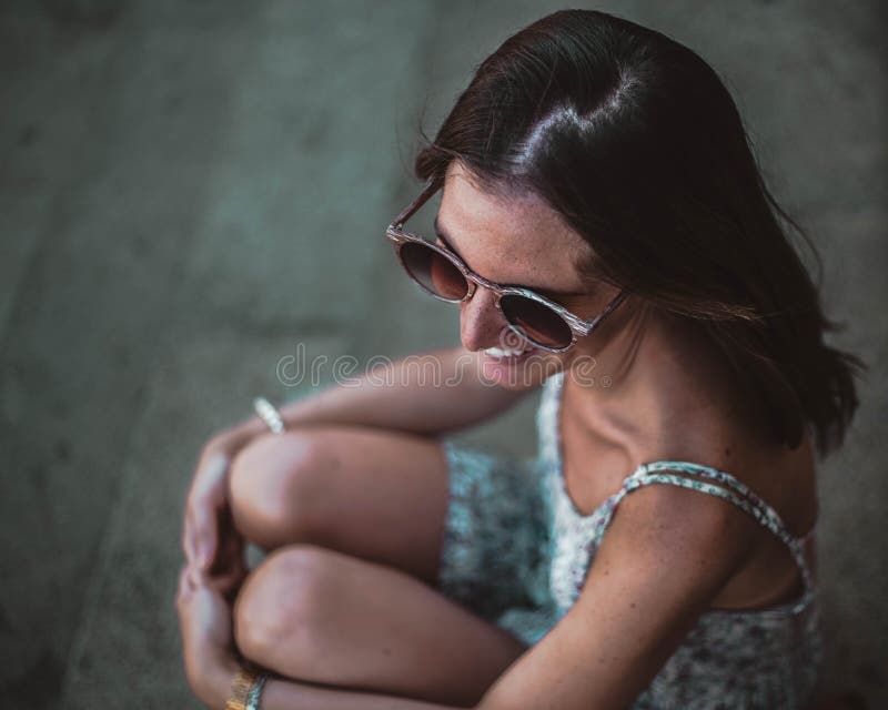 Κλείστε επάνω του όμορφου κοριτσιού brunette στα γυαλιά ηλίου που κάθεται στα σκαλοπάτια Αυτή που κοιτάζει μακριά και που χαμογελ στοκ φωτογραφία με δικαίωμα ελεύθερης χρήσης Κλείστε επάνω του όμορφου κοριτσιού brunette στα γυαλιά ηλίου που κάθεται στα σκαλοπάτια Αυτή που κοιτάζει μακριά και που χαμογελ στοκ φωτογραφία με δικαίωμα ελεύθερης χρήσης