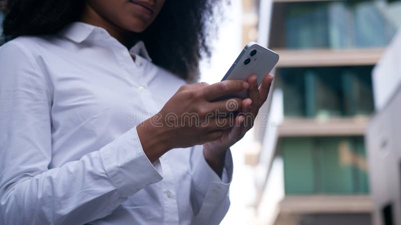 Κλείστε μια άγνωστη γυναίκα Αφροαμερικανή χρήστης που πληκτρολογεί κινητό τηλέφωνο smartphone για επιχειρηματία στο διαδίκτυο στοκ εικόνες