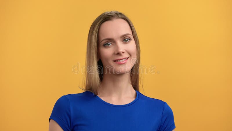 κλειστό πορτρέτο αξιολάτρευτη ξανθιά γυναίκα με φυσική ομορφιά φορώντας μπλε μπλουζάκι ποζώντας απομονωμένη