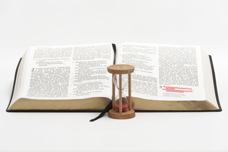 Hourglass and open bible on the book of Ecclesiastes with selective focus on verse 1 of chapter 3 highlighted in red. Isolated on white background. Hourglass and open bible on the book of Ecclesiastes with selective focus on verse 1 of chapter 3 highlighted in red. Isolated on white background.