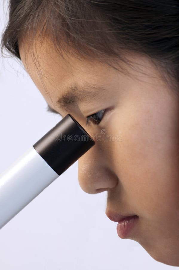 Young Asian girl looking into a microscope. Young Asian girl looking into a microscope