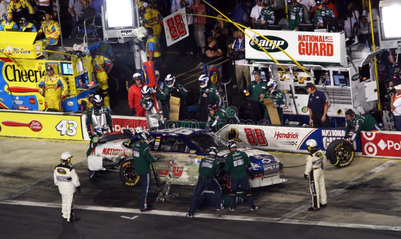 Dale Earnhardt Jr's pit crew races to complete their pit stop as fast as possible as NASCAR officials watch closely during 2008 Coca Cola 600 at Lowes Motor Speedway. Dale Earnhardt Jr's pit crew races to complete their pit stop as fast as possible as NASCAR officials watch closely during 2008 Coca Cola 600 at Lowes Motor Speedway