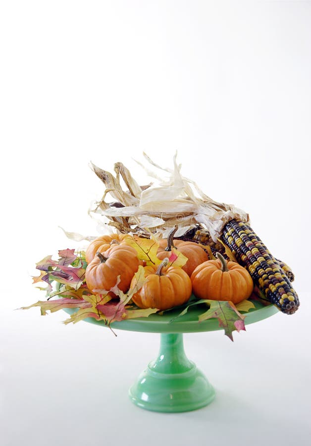 Pumpkins, indian corn and fall leaves on cake pedestal. Pumpkins, indian corn and fall leaves on cake pedestal