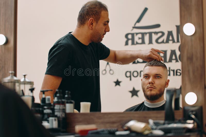 κομμωτής κάνει κομμωτικό με ψαλίδι σε κουρείο. ο δάσκαλος κομμωτής κάνει κομμωτικό με ψαλίδι και χτένισμα.