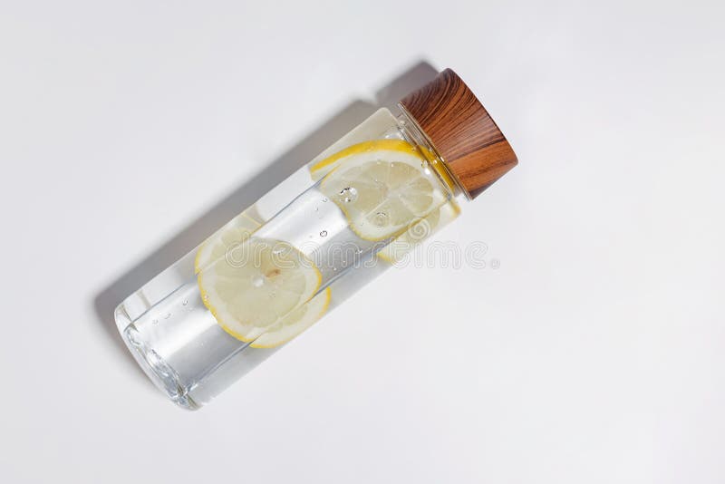 Stylish reusable bottle with lemon infused water isolated on white background. Stylish reusable bottle with lemon infused water isolated on white background