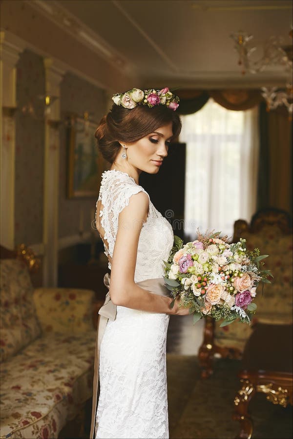 Κομψό, μοντέρνο και όμορφο πρότυπο κορίτσι brunette με το μοντέρνο γάμο hairstyle, με το φωτεινό makeup και με το floral στεφάνι στοκ εικόνες Κομψό, μοντέρνο και όμορφο πρότυπο κορίτσι brunette με το μοντέρνο γάμο hairstyle, με το φωτεινό makeup και με το floral στεφάνι στοκ εικόνες