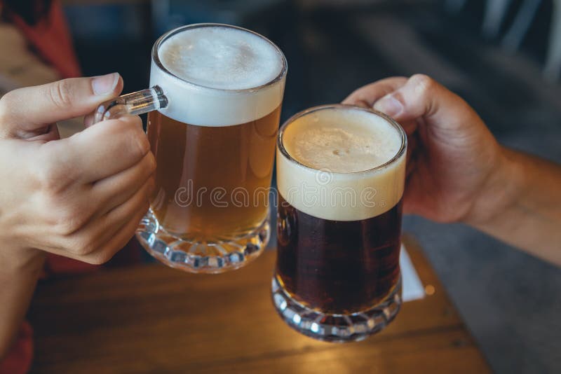 κοντινό πλάνο ανθρώπων που προσκολλώνται σε κούπες μπύρας σε εορτασμό για πρόποση στοκ εικόνα