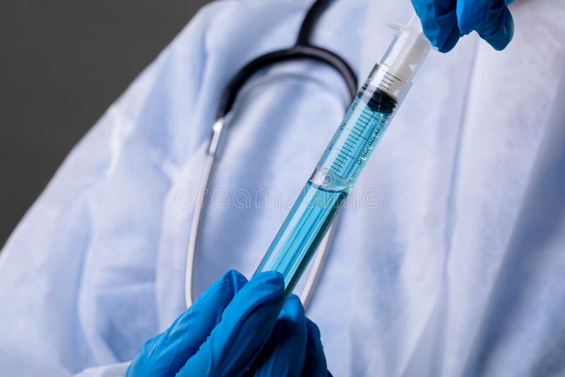 κοντινό πλάνο για την εισαγωγή της σύριγγας στο δοκιμαστικό σωλήνα με χημική ουσία στοκ εικόνες