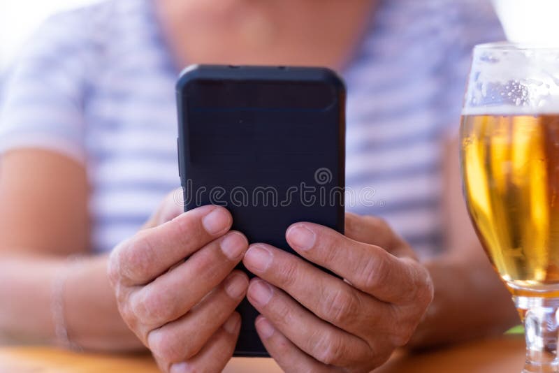 κοντινό πλάνο γυναικείων χεριών κρατώντας κινητό τηλέφωνο με μπλε κάλυμμα. καυκάσια κυρία που κάθεται σε ένα τραπέζι εστιατορίου κ στοκ φωτογραφία με δικαίωμα ελεύθερης χρήσης