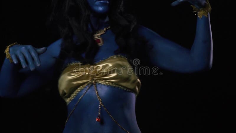 Κοντινό πλάνο ινδής θεάς που χορεύει Kali φορώντας χρυσά ρούχα και κρανία