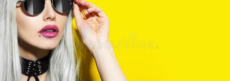 κοντινό πλάνο πορτραίτου μόδας στούντιο από νεαρή όμορφη ξανθιά κοπέλα με γυαλιά ηλίου και μαύρη σοκολάτα σε κίτρινο φόντο. στοκ εικόνες με δικαίωμα ελεύθερης χρήσης