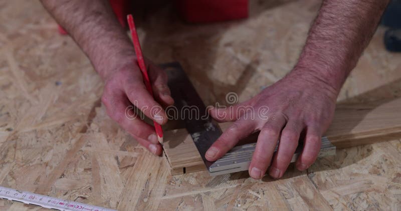 κοντινό πλάνο του ανθρώπου που εγκαθιστά ξύλινα δάπεδα. κατασκευή σε ανακαινισμένη εγκατάσταση παρκέ φιλμ μικρού μήκους