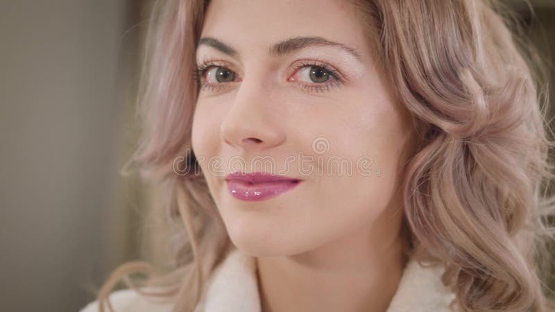 Κοντινό πρόσωπο όμορφου Καυκάσου κοριτσιού με σγουρά μαλλιά και φουντούκια κοιτάζοντας την κάμερα σαν να ασκεί σκόνη προσώπου Νέο